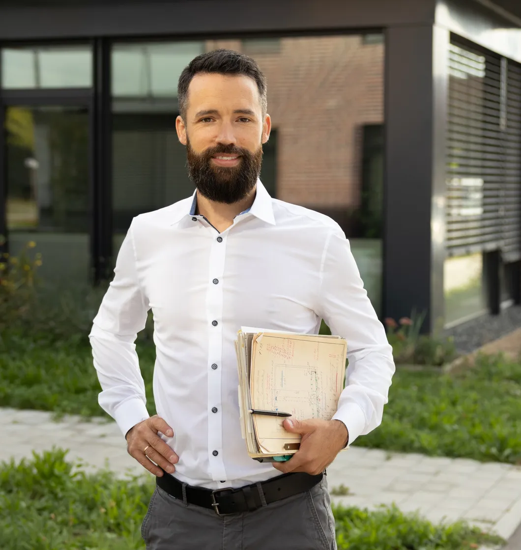 Benjamin Geier mit Unterlagen unter dem Arm vor einem Bürogebäude